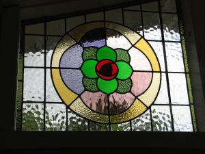 Leadlight stained glass Whangarei. Stained glass rose design with bright coloured green red glass